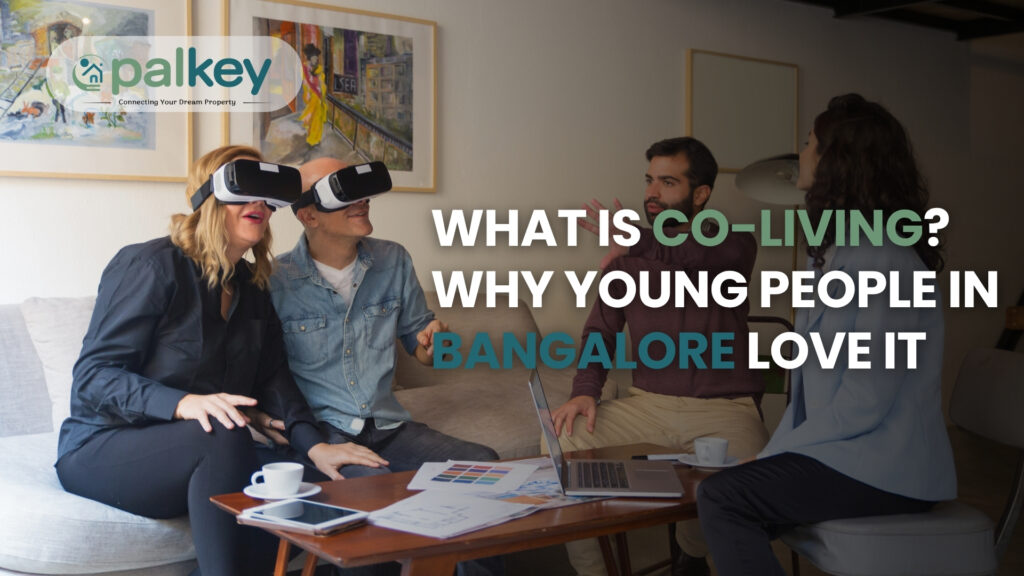 Four young adults in a modern living room discussing a project; two people on the left are wearing VR headsets. The text overlay asks: "WHAT IS CO-LIVING? WHY YOUNG PEOPLE IN BANGALORE LOVE IT."