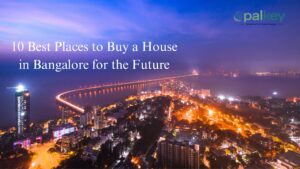A composite image of a brightly lit city skyline at night with a long bridge crossing water. Text reads: "10 Best Places to Buy a House in Bangalore for the Future."
