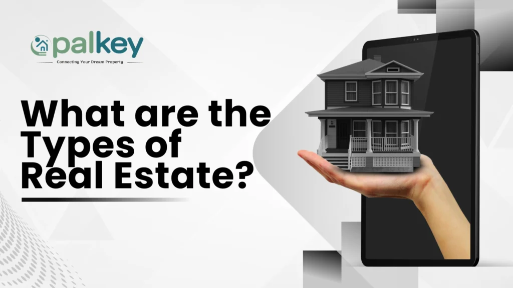 A graphic with the text "What are the Types of Real Estate?". The image shows a hand holding a miniature model of a house in front of a large tablet displaying a real estate graphic. The "opalkey" logo is in the top left corner.